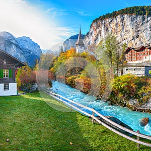 Gorgeous autumn landscape of  alpine village Lauterbrunnen with famous church and Staubbach waterfall