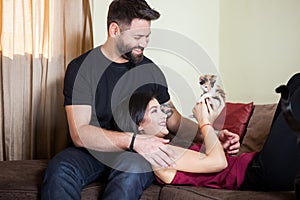 Gorgeous beautiful young couple holding cats in hands