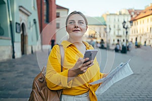 Gorgeous beautiful young woman is messaging on a smartphone on the background of a city street. Beautiful girl talking