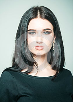 Gorgeous beauty. Girl on confident face enjoy her beauty, light background. Lady brunette in classic elegant black dress