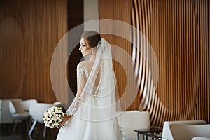Gorgeous beauty portrait of a young bride. Beautiful bride with wedding hairstyle and makeup in a trendy dress with the