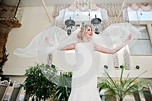 Gorgeous blonde bride with long veil