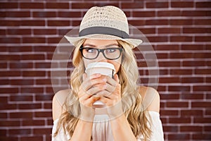 Gorgeous blonde hipster drinking out of take-away cup