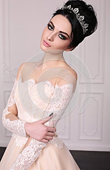 Gorgeous bride with dark hair in luxuious wedding dress