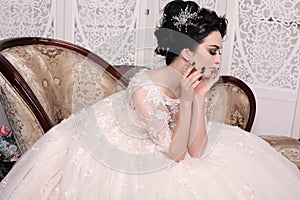 Gorgeous bride with dark hair in luxuious wedding dress