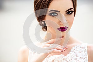 Gorgeous bride with fashion makeup and hairstyle in a luxury wedding dress