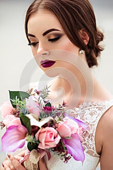 Gorgeous bride with fashion makeup and hairstyle in a luxury wedding dress