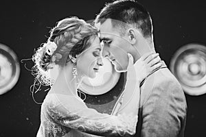 Gorgeous bride and handsome groom touching by faces each other.