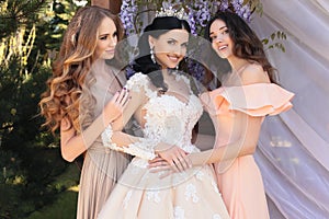 Gorgeous bride in luxurious wedding dress, posing with beautiful bridesmaids in elegant dresses