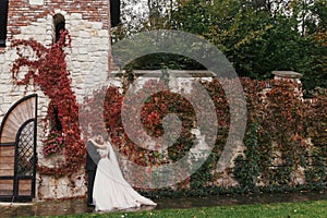 Gorgeous bride and stylish groom gently hugging and smiling at