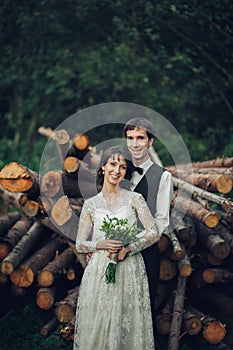 Gorgeous bride and stylish groom walking at sunny landscape, wed