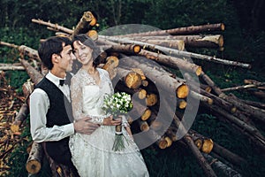 Gorgeous bride and stylish groom walking at sunny landscape, wed