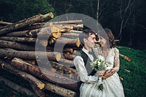 Gorgeous bride and stylish groom walking at sunny landscape, wed