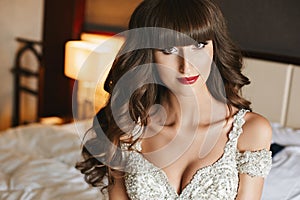 Gorgeous bride with wedding makeup and long wavy hair in bridal dress. Fashion model in elegant wedding dress posing at