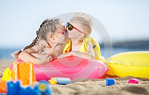 Gorgeous brother and sister sunbathing on a sandy beach