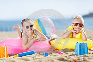 Gorgeous brother and sister sunbathing on a sandy beach