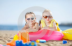 Gorgeous brother and sister sunbathing on a sandy beach