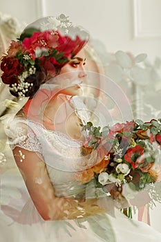 Gorgeous brunette girl in a white dress, with a wreath and a bouquet, multiple exposure