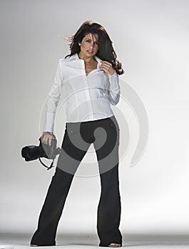 Gorgeous Brunette Model Poses In A Studio Environment Against A White Background Holding Camera Equipment