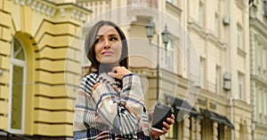 Gorgeous brunette walking in the city and drinking coffee.