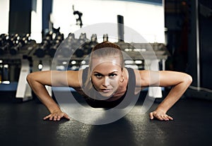 Gorgeous brunette warming up and doing some push ups at gym