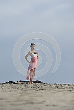 Gorgeous brunette woman in dress walking in the desert sand