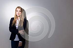 Gorgeous business lady standing against gray background