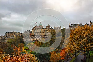 Gorgeous and colorful autumn or early winter`s view of Edinburgh from Princes Street Garden with the sun popping