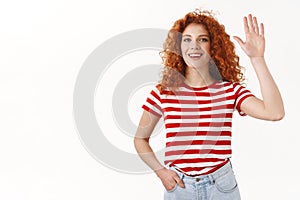 Gorgeous curly-haired caucasian redhead woman raise palm high five smiling amused lively greeting waving hand hello hi