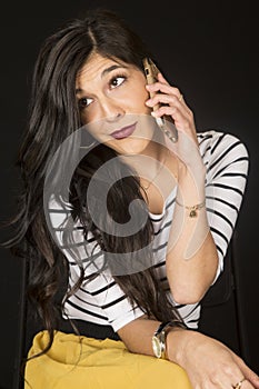 Gorgeous dark model sitting talking on her cell phone