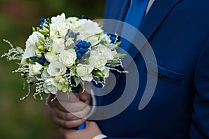 gorgeous elegant groom in blue suit holding stunning stylish bouquet