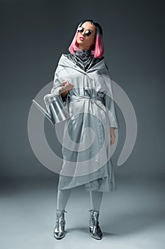 gorgeous fashionable girl in stylish silver clothes and sunglasses posing with watering