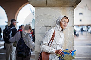 Gorgeous female tourist with a map discovering a foreign city -