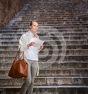 Gorgeous female tourist with a map discovering a foreign city