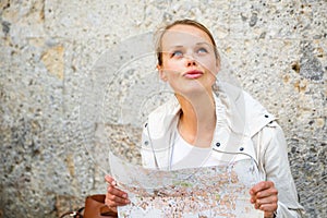 Gorgeous female tourist with a map discovering a foreign city