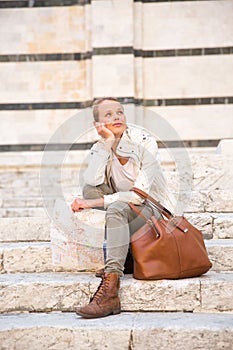 Gorgeous female tourist with a map discovering a foreign city