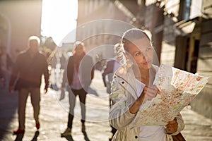 Gorgeous female tourist with a map discovering a foreign city