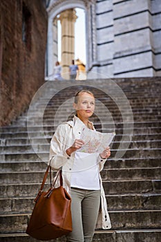 Gorgeous female tourist with a map discovering a foreign city