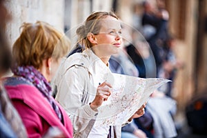 Gorgeous female tourist with a map discovering a foreign city