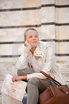 Gorgeous female tourist with a map discovering a foreign city s