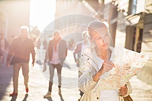 Gorgeous female tourist with a map discovering a foreign city photo