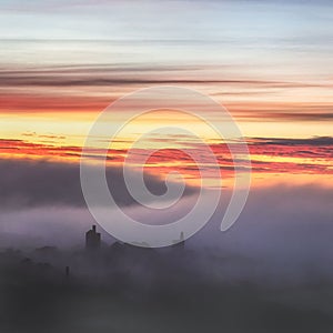 Gorgeous foggy sunrise at Carn Brea Castle in Cornwall with thick clouds going over the keep