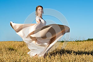 Gorgeous girl in beautiful dress in field