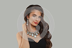 Gorgeous glamorous woman jewelry model with diamonds posing on gray background
