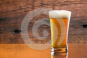 Gorgeous glass of delicious beer with barn wood background