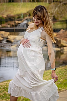 A Gorgeous Glowing Pregnant Woman Poses In An Outdoor Environment