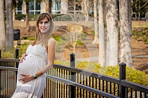 A Gorgeous Glowing Pregnant Woman Poses In An Outdoor Environment