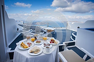 Gorgeous greek breakfast in idyllichotel varanda with sea and caldera view of Santorini, greece photo