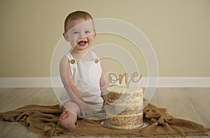 Gorgeous happy blue eyed baby boy in neutral tones turns one