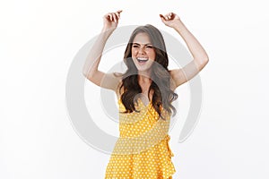 Gorgeous happy carefree caucasian woman dancing celebrating win, feeling lucky and upbeat, lift hands enthusiastic fist